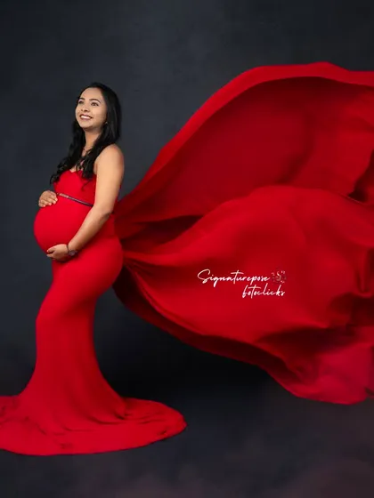 The flowing red fabric creates a sense of motion and drama in this elegant side-profile studio shot.