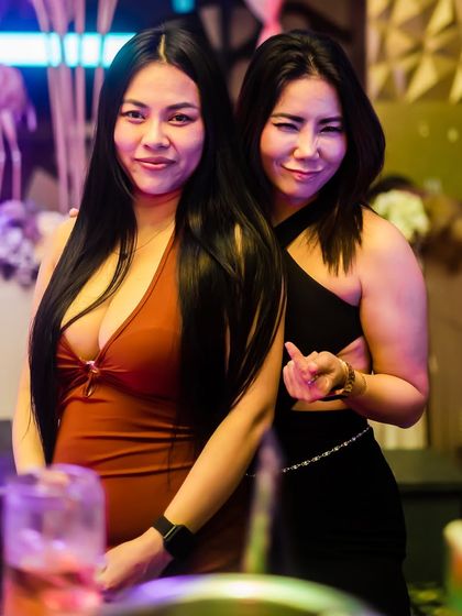 Friends posing for a photo near the bar, enjoying the vibrant atmosphere.