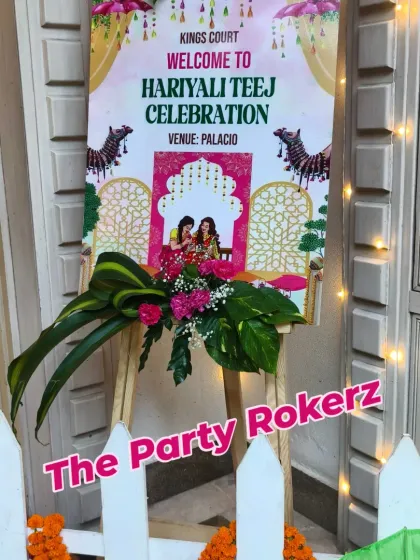 A close-up of the custom welcome sign for a Hariyali Teej celebration, adorned with fresh floral arrangements.