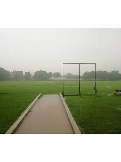 A view of our lush green cricket ground on a quiet, rainy day. This field is our canvas, where countless hours of hard work are put in by our aspiring cricketers.