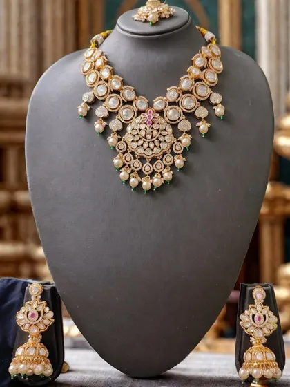 Elegance in simplicity. This beautiful polki and pearl necklace set is perfect for pre-wedding functions like an engagement or sangeet. The set, available for rent, includes a graceful necklace, matching jhumkas, and a delicate maang tikka, offering a sophisticated and polished look.