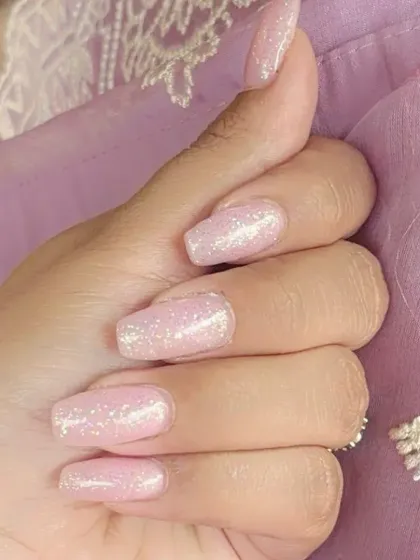 A lovely set of coffin-shaped nails with a soft, shimmery pink gel polish, perfect for an everyday elegant look.