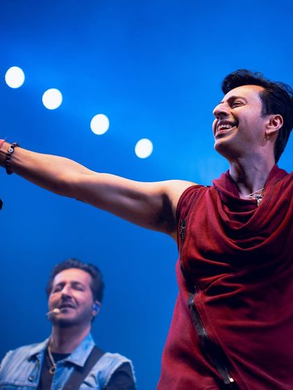 A joyful moment captured between Salim and Sulaiman on stage, showing the chemistry they bring to their live shows.