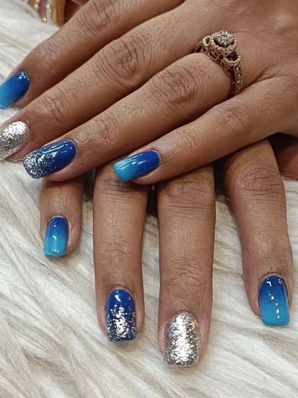 A stunning blue ombre that fades from deep navy to a bright sky blue, accented with full-coverage silver glitter nails. This look is bold, vibrant, and full of sparkle.