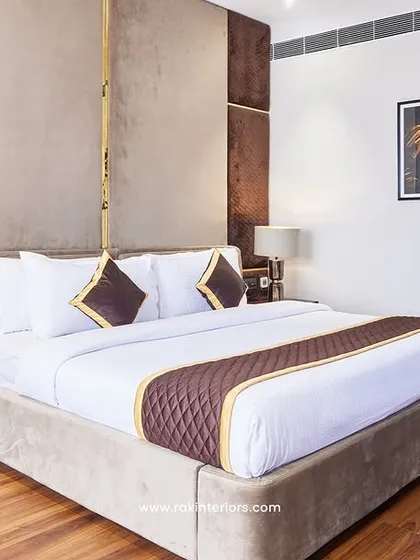 A well-designed hotel room should be a sanctuary. This executive room combines a rich, warm color palette with custom headboard paneling and layered lighting to create a space that is both professional and deeply comfortable for guests.