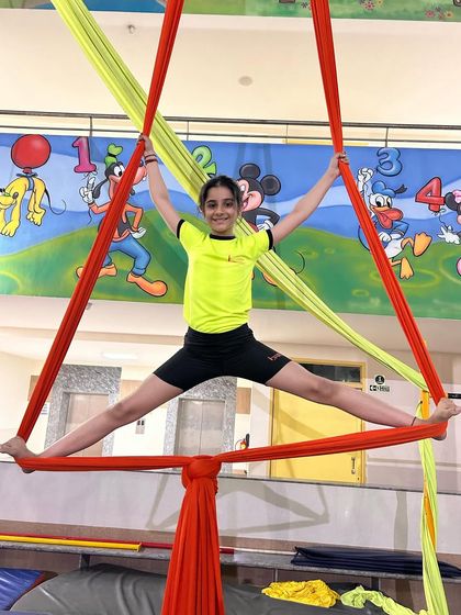 Holding a wide split within a triangle formed by the silks, this student shows excellent control and flexibility.