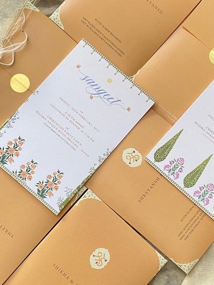 A flatlay of the minimal invitation suite, showing the different event cards and the custom monogram stickers used to seal the envelopes. Every element is designed to be cohesive.