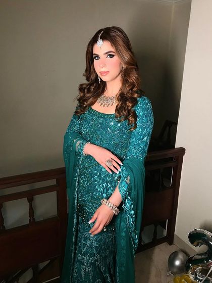 A client ready for a cocktail event, with her hair styled in soft, voluminous curls. The side part and gentle waves frame her face and highlight her features.