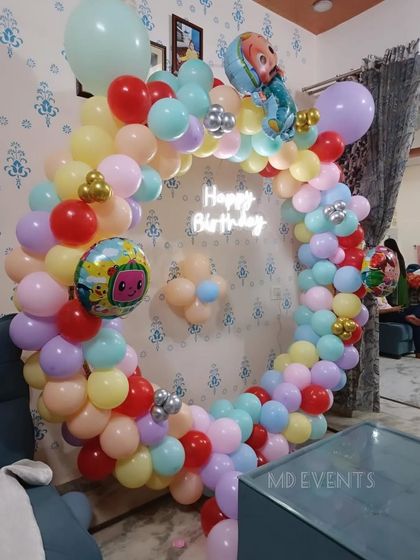 A side angle of the Cocomelon balloon arch, highlighting the mix of pastel colors and the placement of the character foil balloons.
