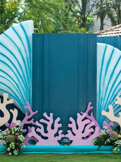 A closer look at the aqua-themed mehendi backdrop, designed to be the perfect photo booth. The central panel provides a clean space for group photos, framed by whimsical sea-inspired elements.