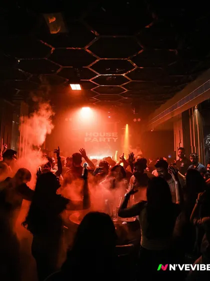 The club is engulfed in red light and smoke as the crowd dances. This image perfectly captures the intense, high-energy atmosphere of a peak-time set.