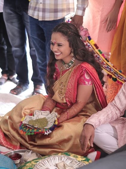 A bride receiving blessings during her Ganesh Poojan. Her look is inspired by the divine grace of Radha, with soft makeup and a traditional saree.