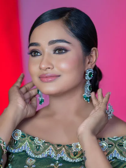 A close-up portrait of the green blouse look, highlighting the beautiful eye makeup and flawless skin.