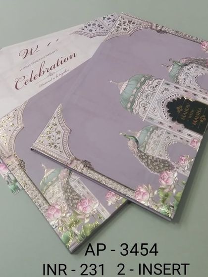 A lovely lavender-colored card featuring palace domes and peacocks. The silver foil accents and elegant script make this an affordable yet stylish choice for a modern Indian wedding.