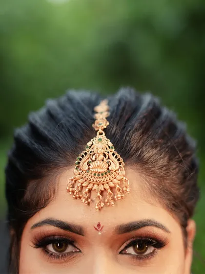 A detailed shot focusing on the exquisite temple jewelry maang tikka. I love capturing these small details that are so significant to the overall bridal look.