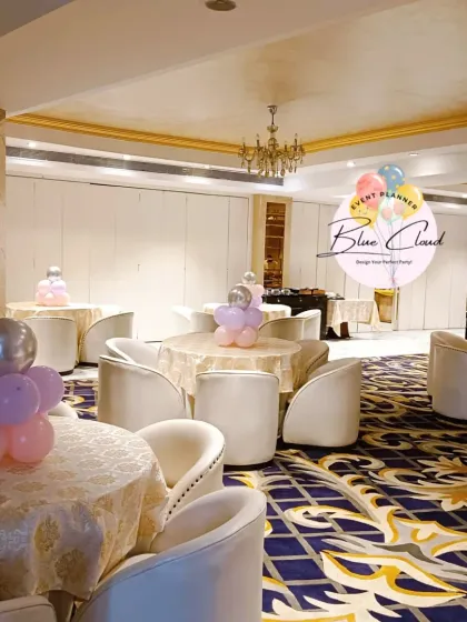 Elegant table centerpieces made of pastel pink and purple balloons in a banquet hall.