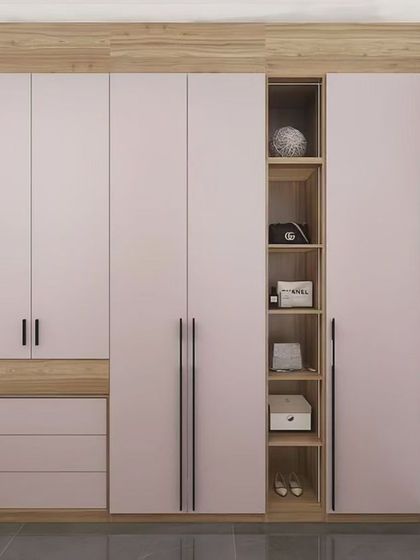 A bedroom wardrobe design that combines soft pink doors with natural wood accents. We integrated a vanity table and drawers into the unit, creating a seamless and space-saving solution.