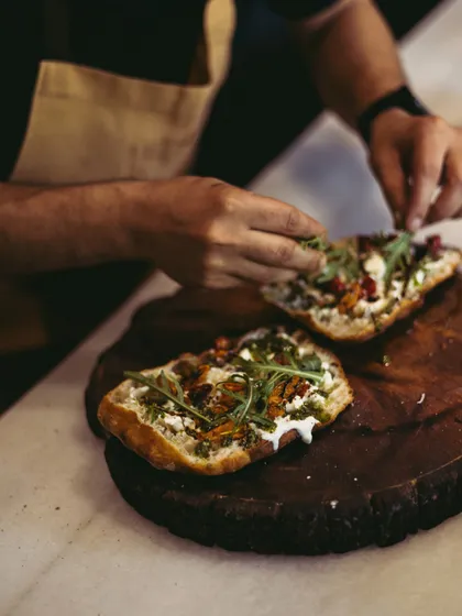 A final touch of fresh arugula on my Stracciatella Bruschetta. It's a cheesy, crispy delight that's perfect for any pizza lover.