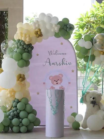 A closer look at the welcome backdrop for Aarshiv, featuring a cute teddy bear and an organic balloon arch.