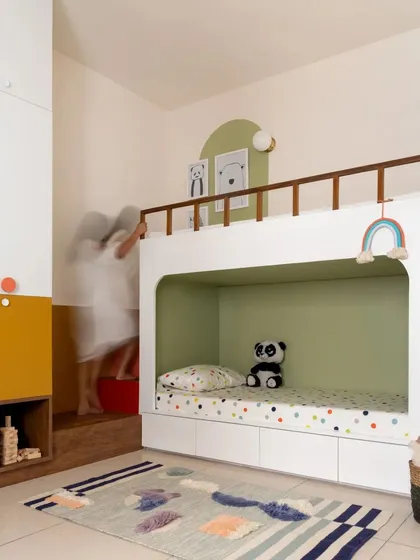 A motion-blur shot capturing the dynamic use of the custom-designed bunk bed and integrated staircase in the children's room.