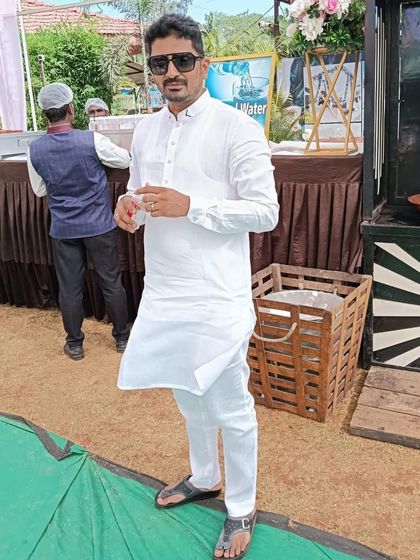 Beaming with satisfaction! A happy client enjoys an outdoor event in a classic, crisp white kurta, showcasing the simple joy of a perfect fit.