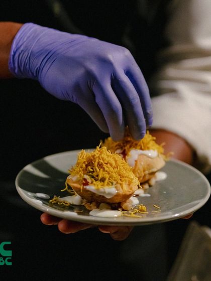 A classic Indian street food favorite, Dahi Puri, prepared with care by one of our chefs. It's a burst of crispy, tangy, and sweet flavors.