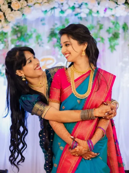 A beautiful, candid photo of the bride-to-be sharing a hug and a smile with a close friend or sister.