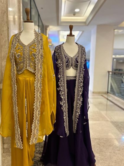 A full-length view of the yellow and purple lehenga sets, perfect for a sangeet or reception.