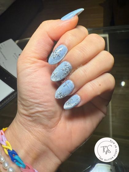 Another angle of the lovely snowflake nails, showing how the silver details shimmer against the cool blue background.