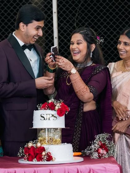 Surrounded by loving family, the couple shares a laugh during their cake cutting. We make sure to include these precious moments with loved ones in our engagement photography.