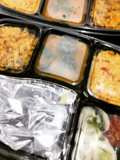 Our sealed meal trays keep your food fresh and hygienic during delivery. This particular meal includes different rice preparations and curries, showcasing the variety our KitchenStars bring to your table every day.