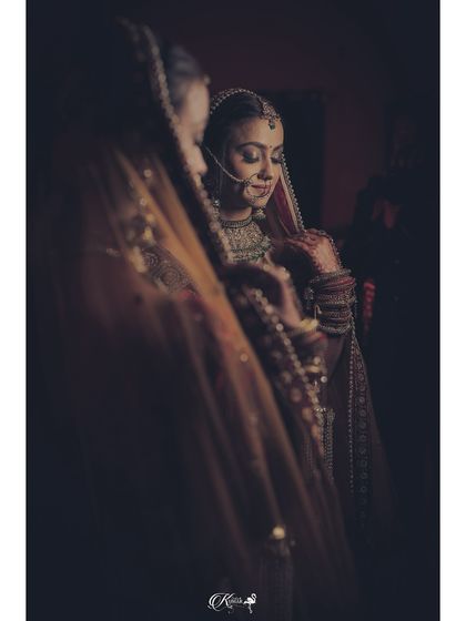 A bride looking at her reflection in a mirror, a classic and introspective getting-ready shot.