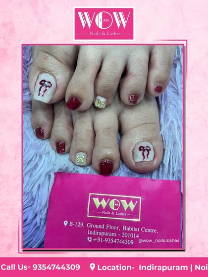 A cute and festive pedicure design. This look features a deep red polish with accent toes showcasing adorable, hand-painted bow art.