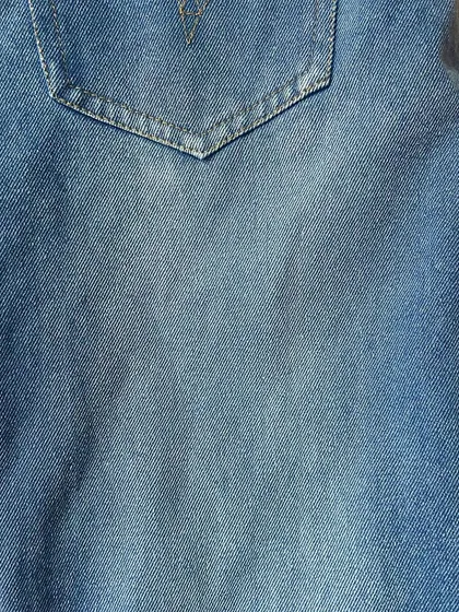 The texture and light fading on a pair of custom-made blue jeans, showing the quality and character of the denim I use.