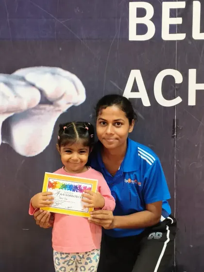 A sweet moment between a student and her coach as she receives her well-deserved certificate of achievement.