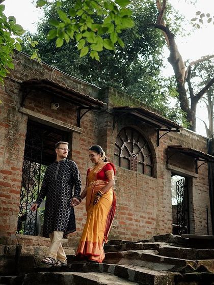 A couple descends the old stone steps, hand in hand. The exposed brick and archways create a rustic, historical backdrop for their journey together.