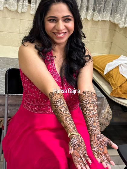 A happy bride showcasing her beautiful and intricate mehendi. Her smile radiates joy, and the design is a perfect blend of traditional motifs like peacocks, elephants, and lotuses.
