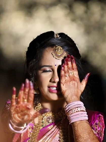 A playful and artistic shot. Even with half her face covered, the eye makeup and radiant skin are prominent, showing the power of a well-executed look.