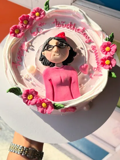 A personalized cake for a 60th birthday, with a hand-sculpted caricature of the birthday mom.