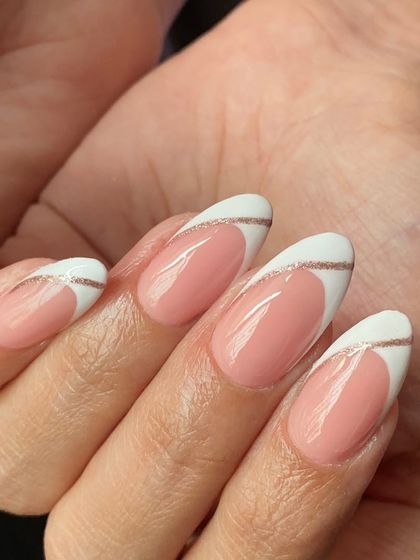 A modern take on the French manicure. This design features a classic white tip with a delicate, wavy rose gold glitter line for a touch of elegance.