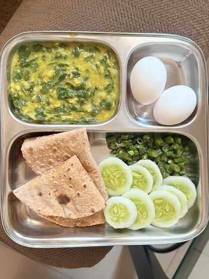 A high-protein meal of chapati with dal palak, boiled eggs, and a side of sautéed beans and cucumber.
