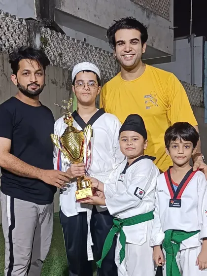 The coaching team and some of our youngest champions. We are building the next generation of martial artists, one student at a time.