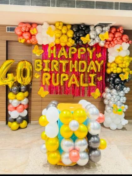 A vibrant decoration for a 40th birthday party. This setup includes a red shimmer backdrop, large gold foil '40' numbers, and a full balloon frame in a festive color palette.