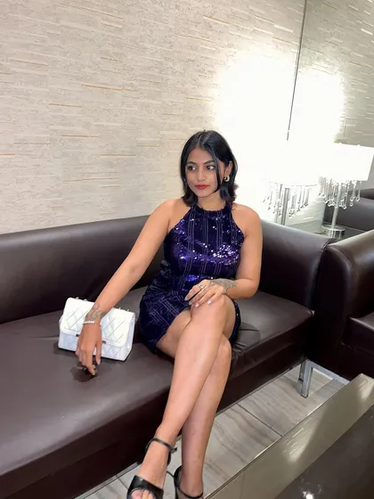 Relaxing on a couch in my blue sequined birthday dress. It's a comfortable yet glamorous choice for a night of celebration.