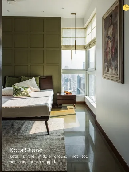 Kota stone is the middle ground, not too polished, not too rugged. Here, its smooth, cool surface provides a perfect floor for a sunlit bedroom, balancing the warmth of the wood and the olive green wall.