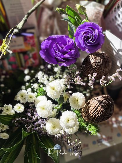 The rich purple roses and natural dried elements in this executive hamper create a composition of depth and presence. Every flower and texture is chosen to reflect the qualities of a strong leader.