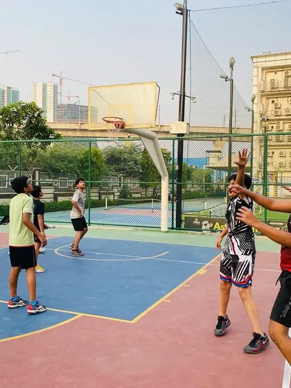 A player takes a jump shot while a defender closes in. This is practice for making shots under pressure.