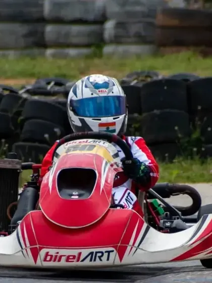 A front-facing shot of a Birel ART kart on the track, demonstrating the vehicle's aggressive design and the driver's complete focus.