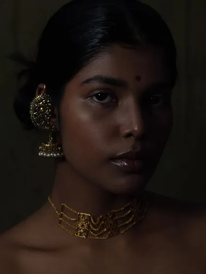 I love playing with shadows and low-key lighting to create something truly artistic. This portrait uses a painterly approach to light, sculpting the model's features and highlighting the warm tones of the gold jewelry against her skin. It shows my ability to create deep, moody, and soulful beauty images.
