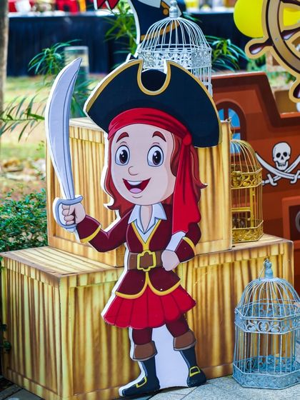A friendly pirate girl cutout stands guard by treasure chests, adding to the adventurous atmosphere.